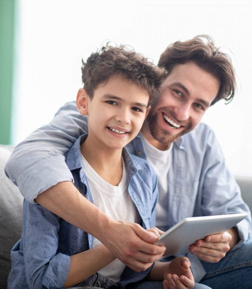 family-time-happy-dad-and-son-using-digital-tablet-browsing-internet-online-at-home-sitting-e1632233068896.jpg